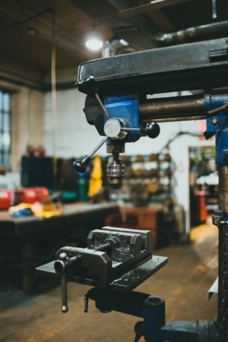 Bench drill press with a machine vice clamped to the table