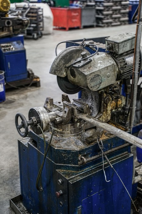 Cold saw cutting machine on a workshop floor