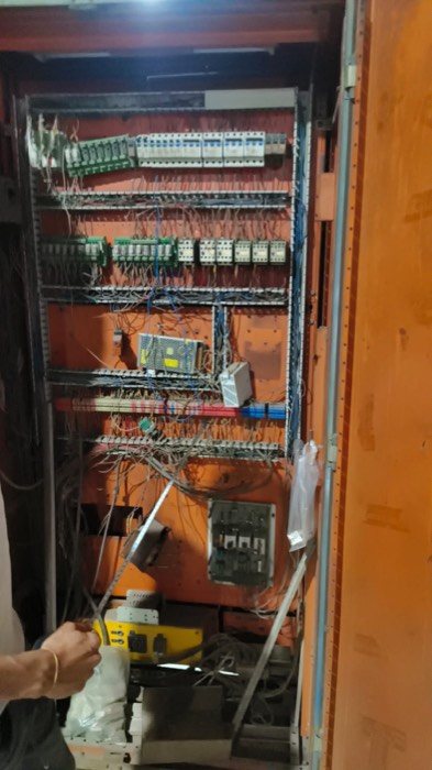 Industrial control panel cabinet being rewired, showing MCBs, relay bases, contactors and ferruled terminal rails