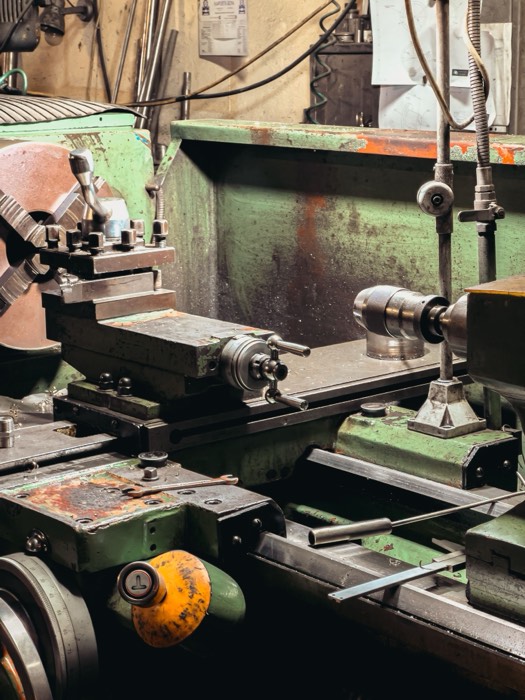 Engine lathe bed, chuck and tailstock in a machine shop