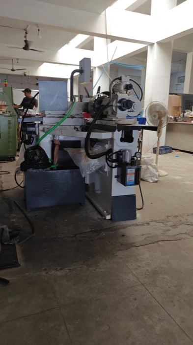 Grinding machine with hydraulic power pack and column-mounted control box on a workshop floor in Gujarat