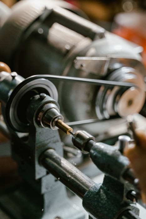 Close-up of a lathe spindle and belt drive with work held in the chuck